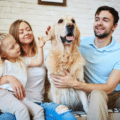 Family of 3 sitting in a sofa with pet dog